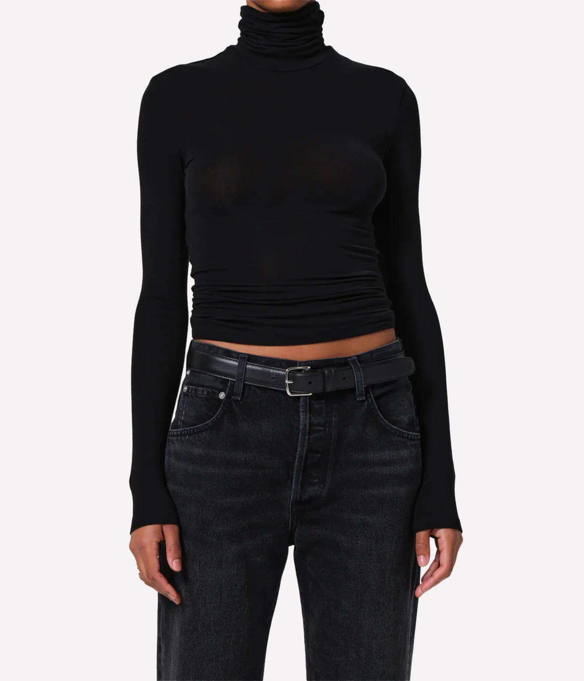 Black turtleneck long sleeve top on a model with black jeans on a white background