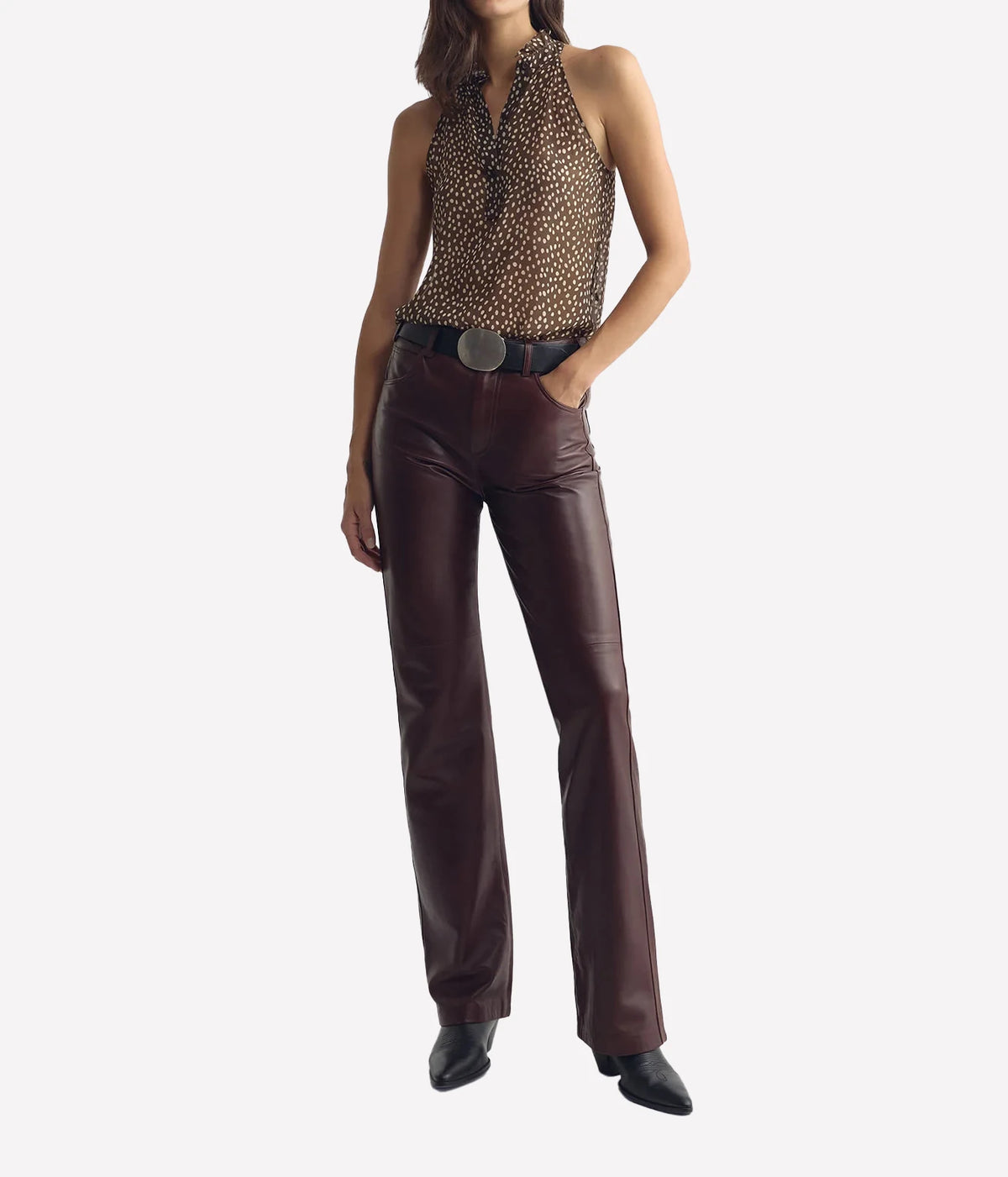 Full-length view of a model wearing the Nili Lotan Daniella Top in Brown Cream Wild Dots with Burgundy Trousers and a Black Belt