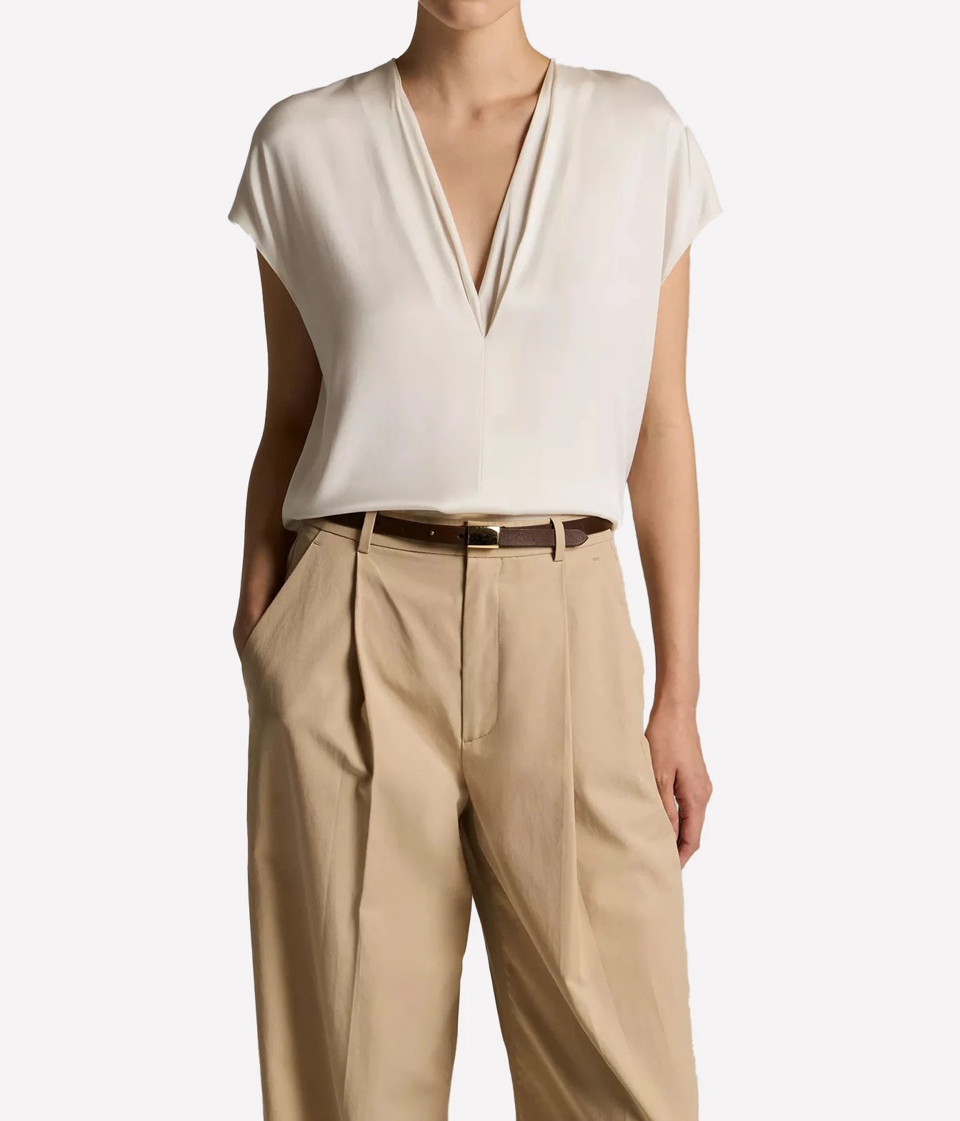 A model wearing a cream-colored short-sleeve V-neck top