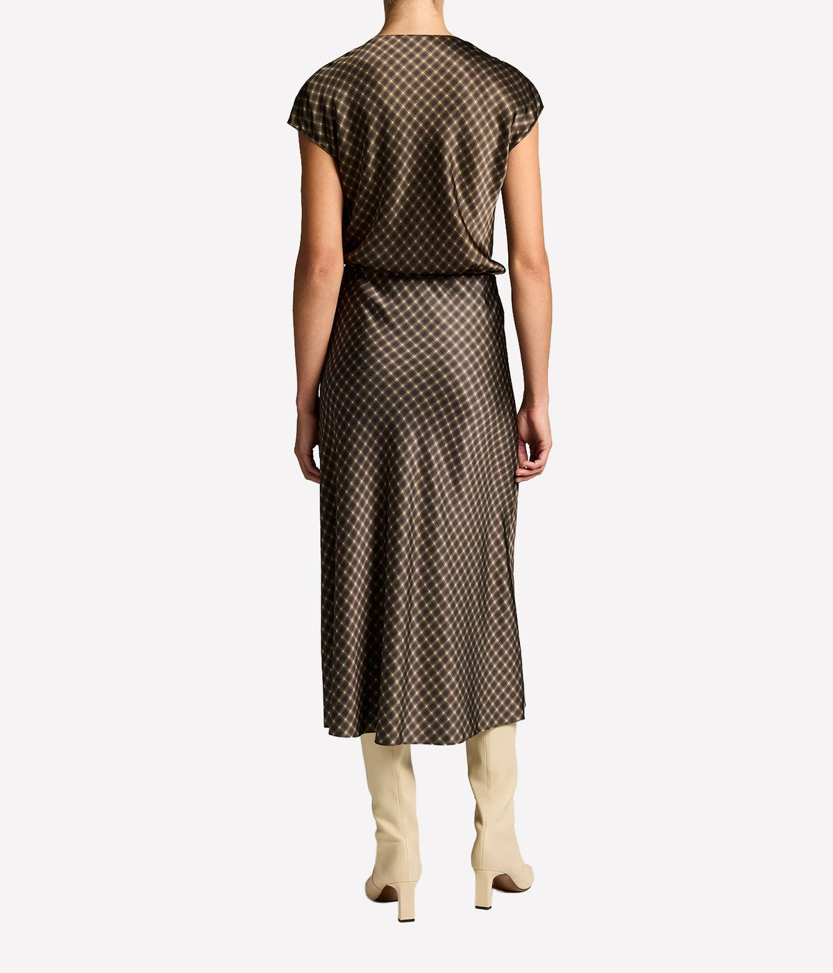 Back view of a model wearing the Vince Ombre Plaid Skirt In Black Camel with the matching blouse and cream knee-high boots