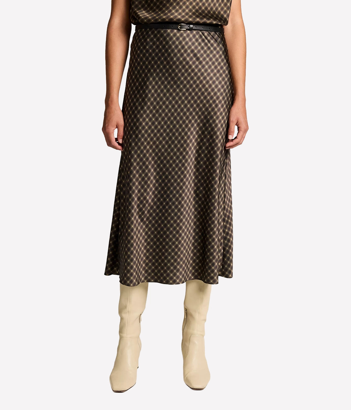 Front view of a model wearing the Vince Ombre Plaid Skirt In Black Camel with a thin black belt and cream knee-high boots, showing the bias-cut midi length