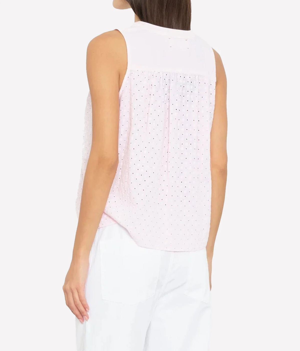 model wearing Xirena Miki Top in Pale rose - sleeveless light pink blouse shot from behind
