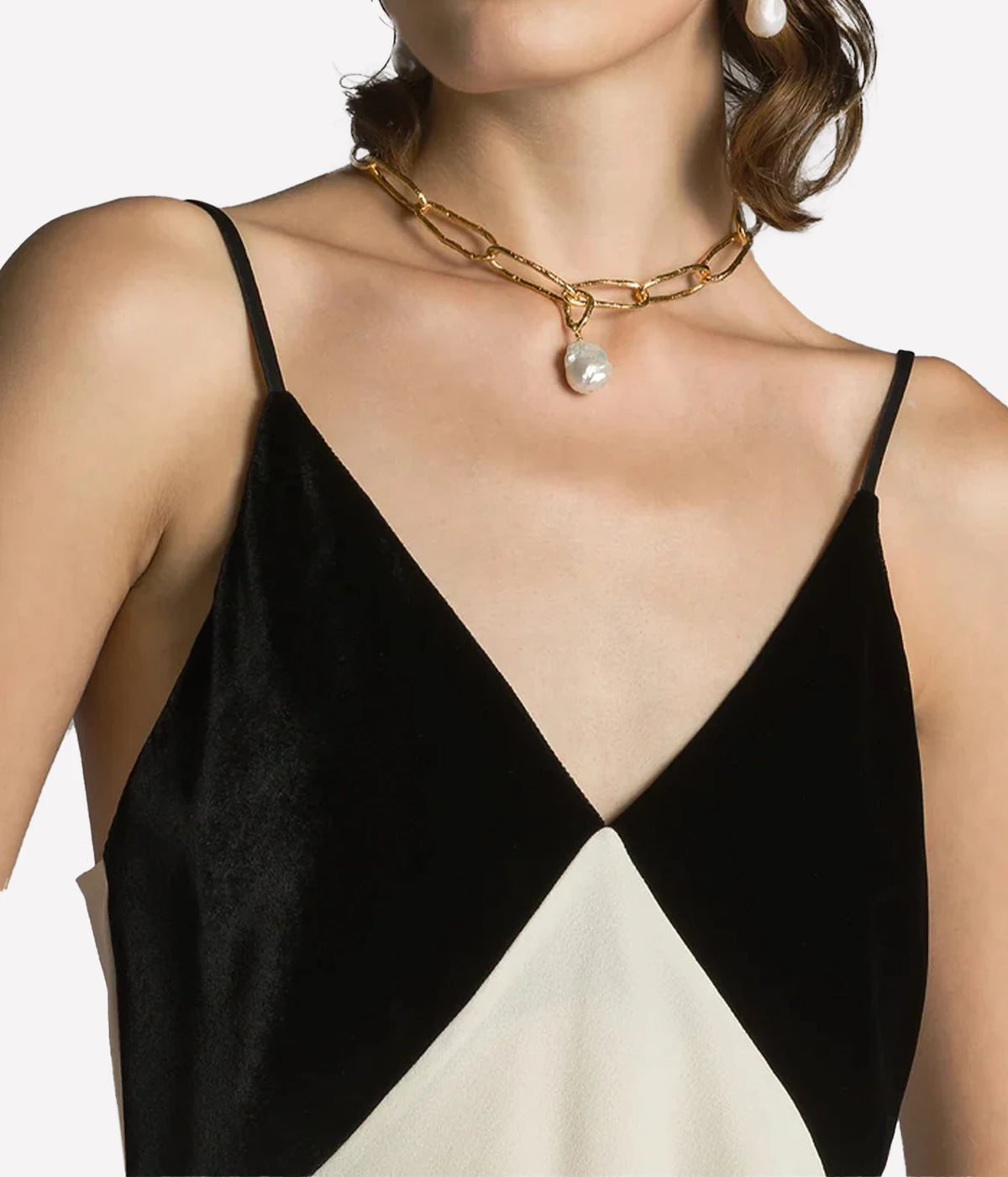 Close-up of a woman wearing the Forte Forte satin and velvet slip top in Diamond with a gold necklace, showing the velvet cups and thin straps.