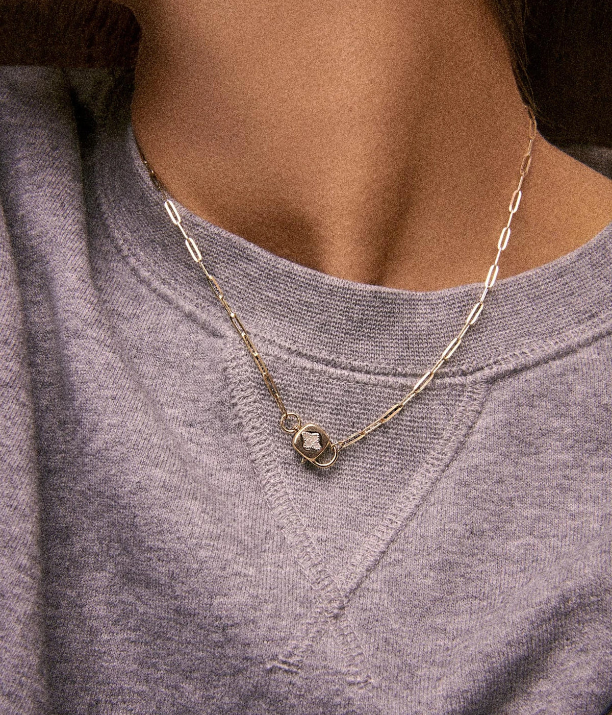 Model wearing the Pascale Monvoisin Louise Necklace layered with a longer fine gold chain over a mauve-grey t-shirt