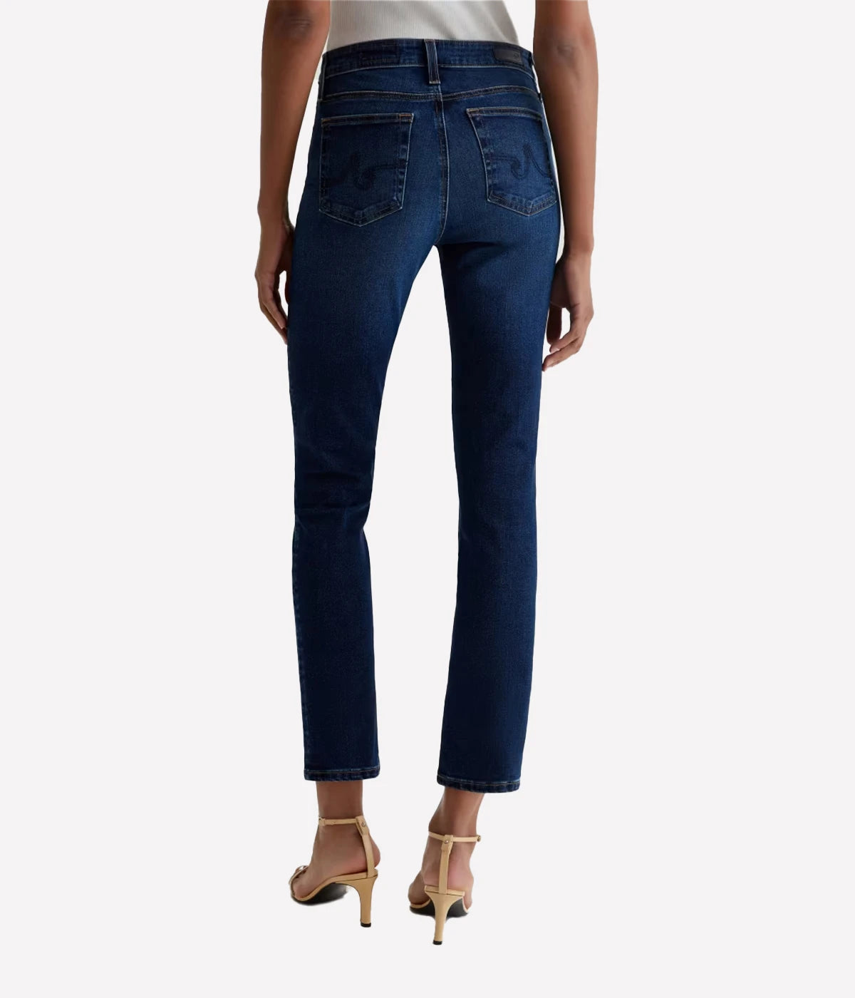 Person wearing dark blue jeans on a white background