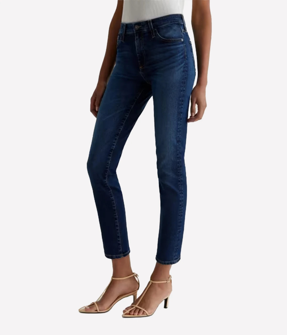 Dark blue jeans worn by a person on a white background