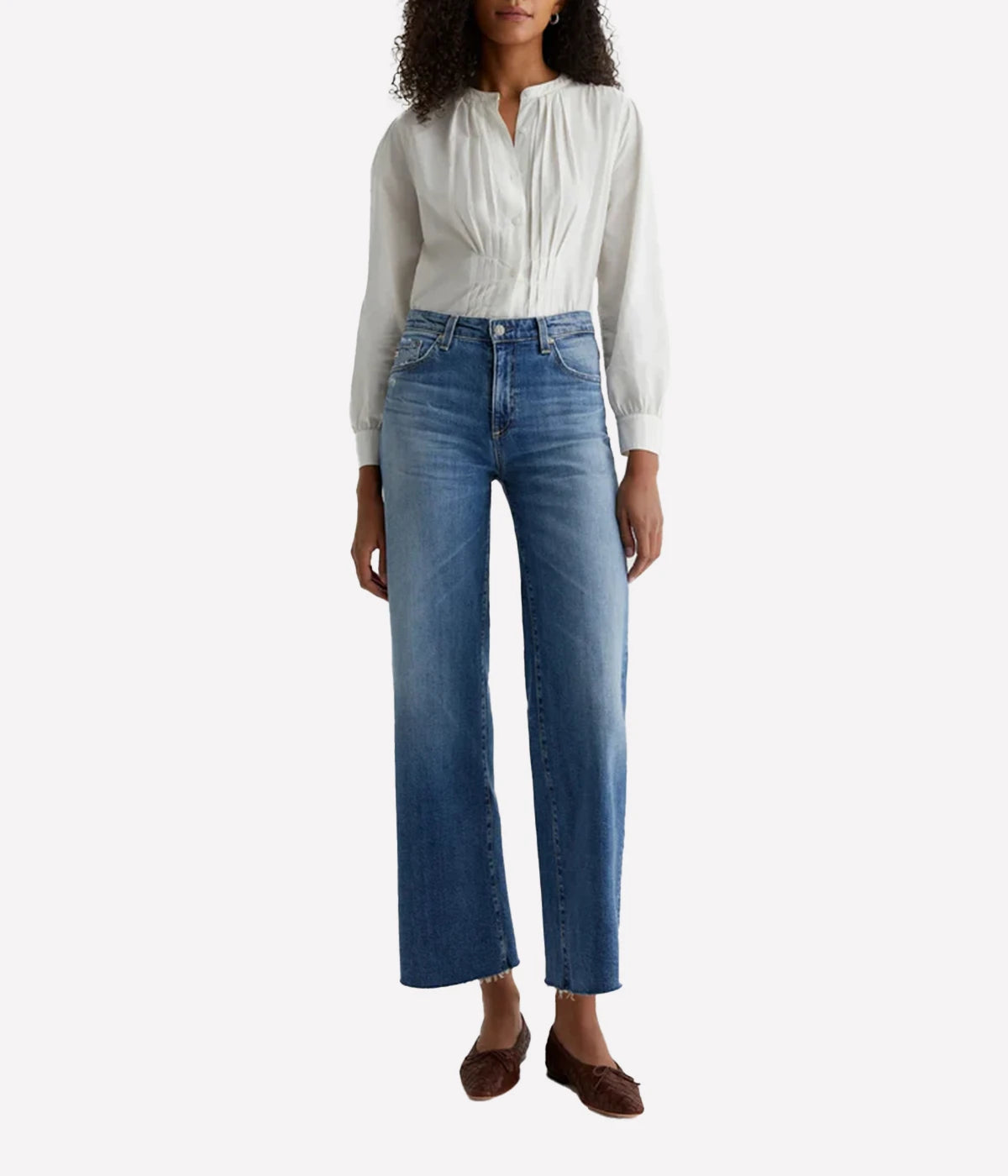 Person wearing a white blouse and blue jeans on a white background