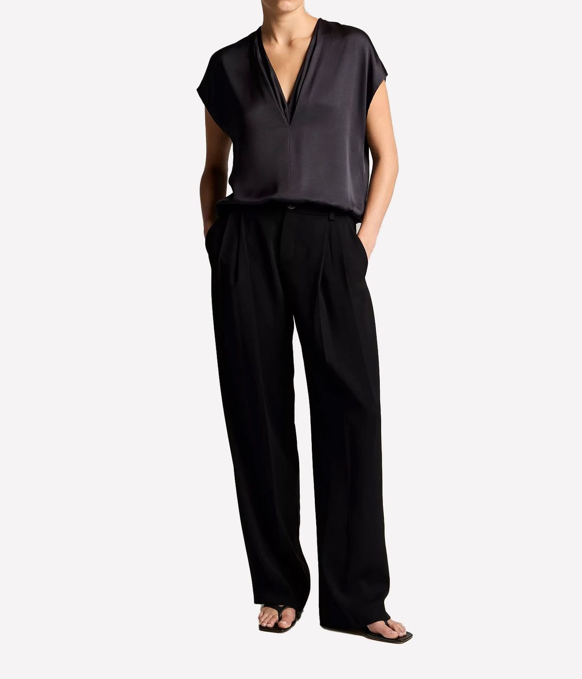 Woman wearing an ink V-neck shell top with black trousers