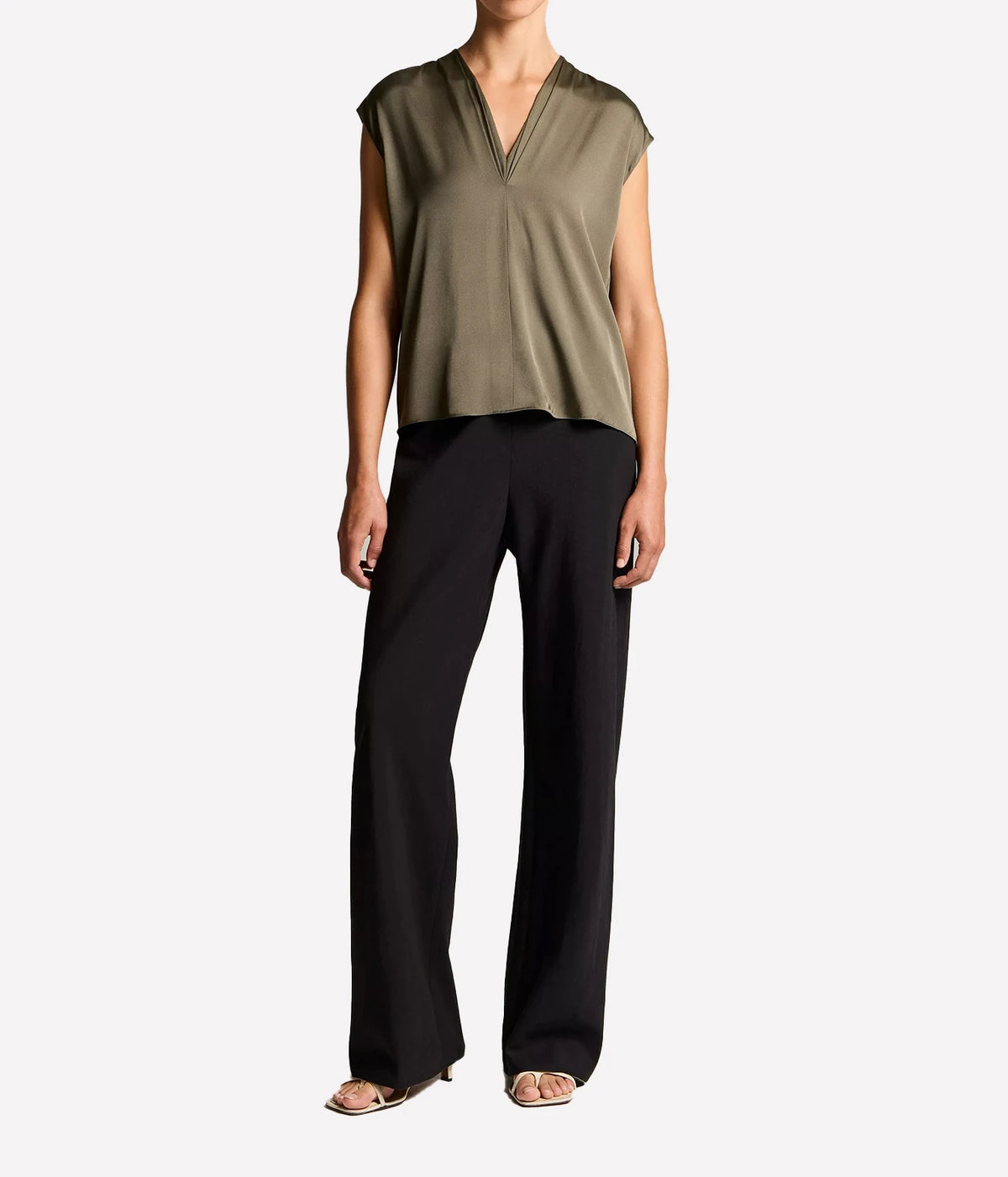 Woman wearing a pine grove V-neck shell top with black trousers