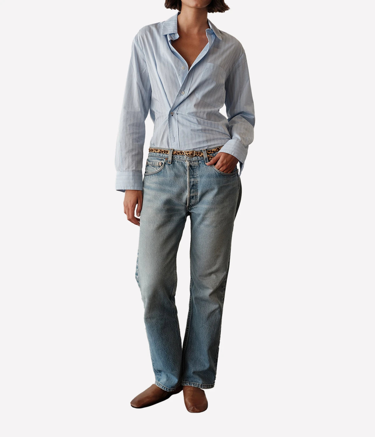 Full-length view of a model wearing the CISSA Daily Shirt in Blue Needle tucked into light-wash straight-leg jeans with brown loafers