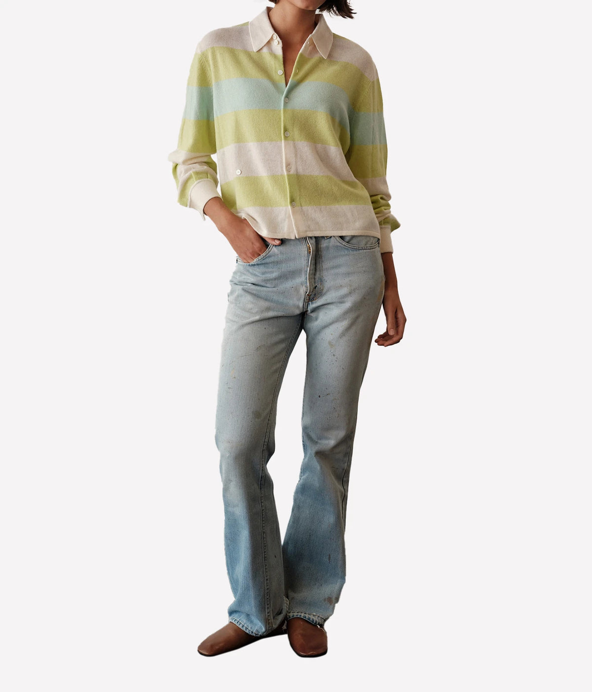 Front view of a model wearing the CISSA Rugby Cardigan in Sorbet Swirl buttoned and tucked into light-wash flared jeans with brown loafers, showing the white collar and wide mint, lime green and ivory stripes