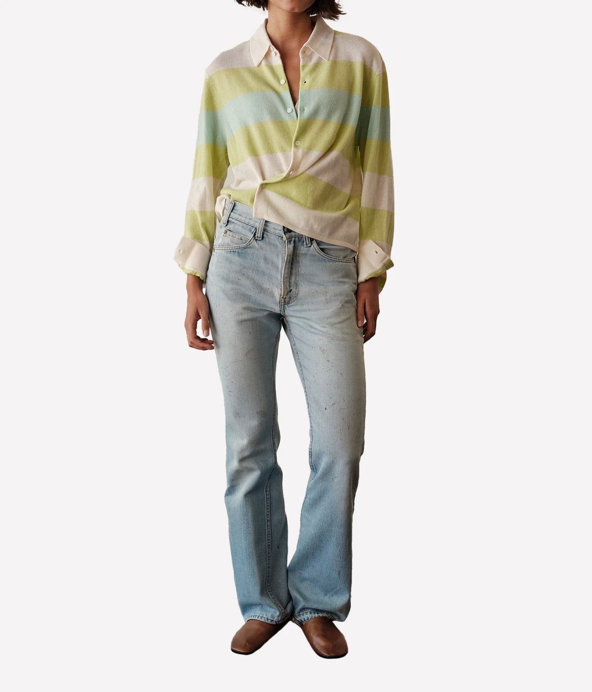 Full-length view of a model wearing the CISSA Rugby Cardigan in Sorbet Swirl tucked into light-wash flared jeans with brown loafers
