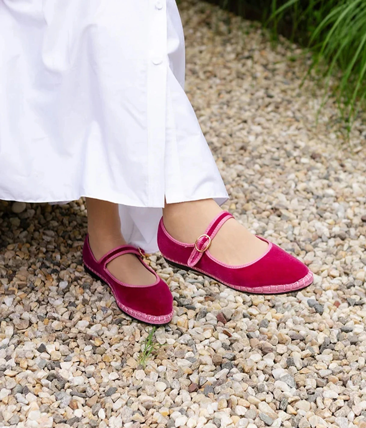 Model wearing the Flabelus Frances in Rosa with a long white button-front dress, showing the cotton velvet uppers and buckle straps from the side