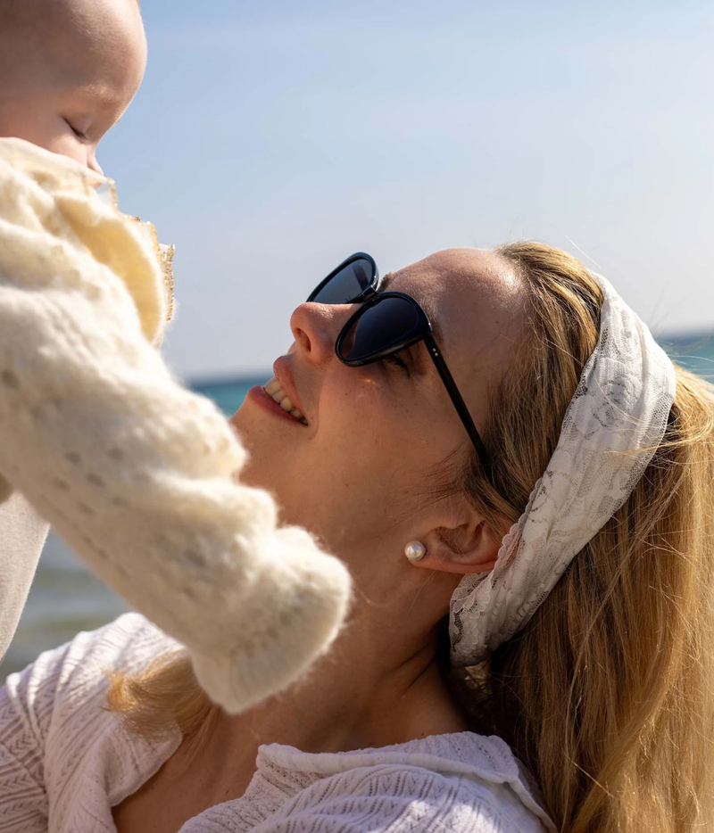 A woman wearing black sunglasses with dark lenses
