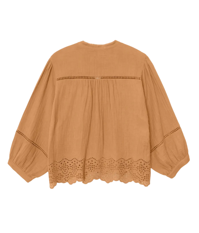 A tan cotton eyelet blouse with long balloon sleeves, featuring decorative eyelet embroidery along the neckline, cuffs, and hem, shown against a plain white background.