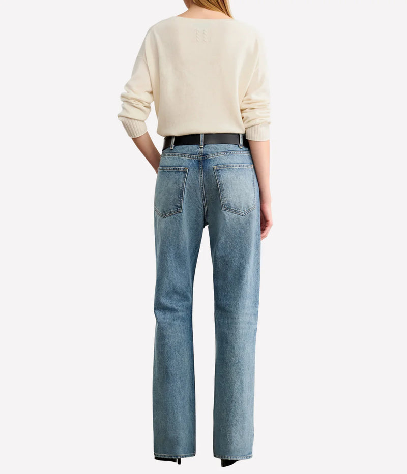 Person wearing a cream sweater and light blue jeans on a white background. Nili Lotan sweater