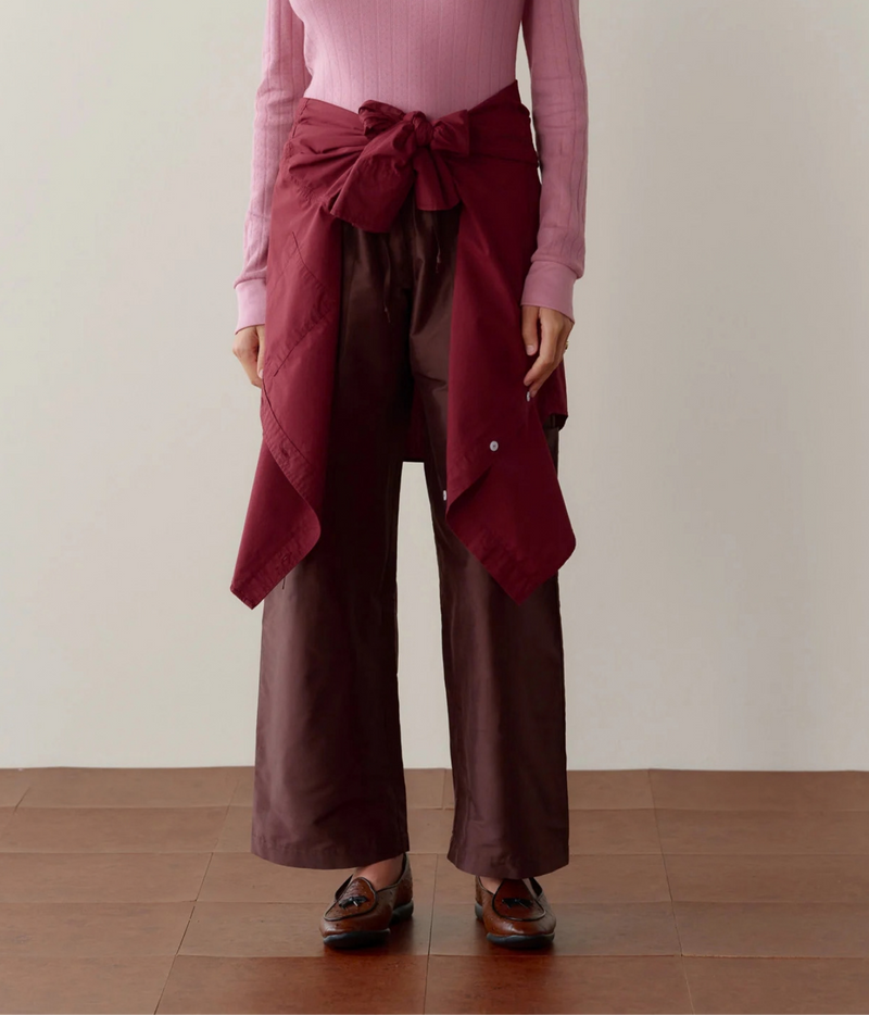 DONNI. Silk Taffeta Cargo Pant in Espresso styled on model with burgundy knit tied at the waist, front view.
