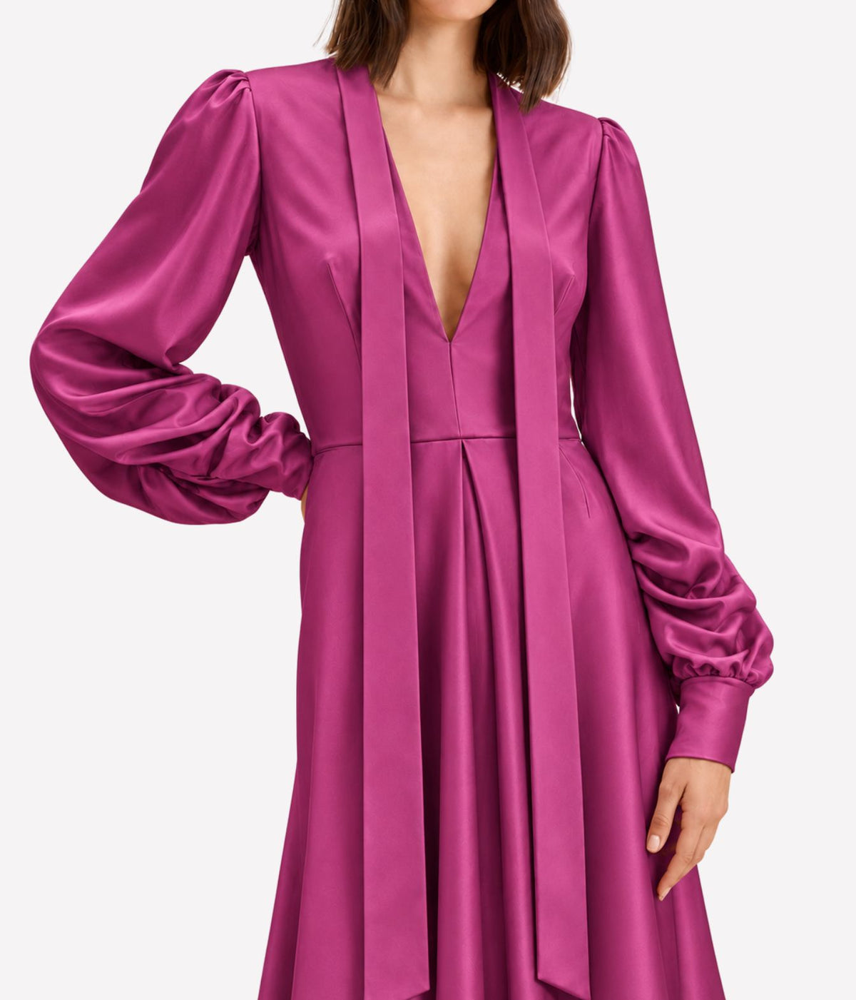 Close-up of a model wearing the Raquel Diniz Valerie Dress In Fuchsia, showing the deep V-neckline, draped neck ties and voluminous gathered sleeves