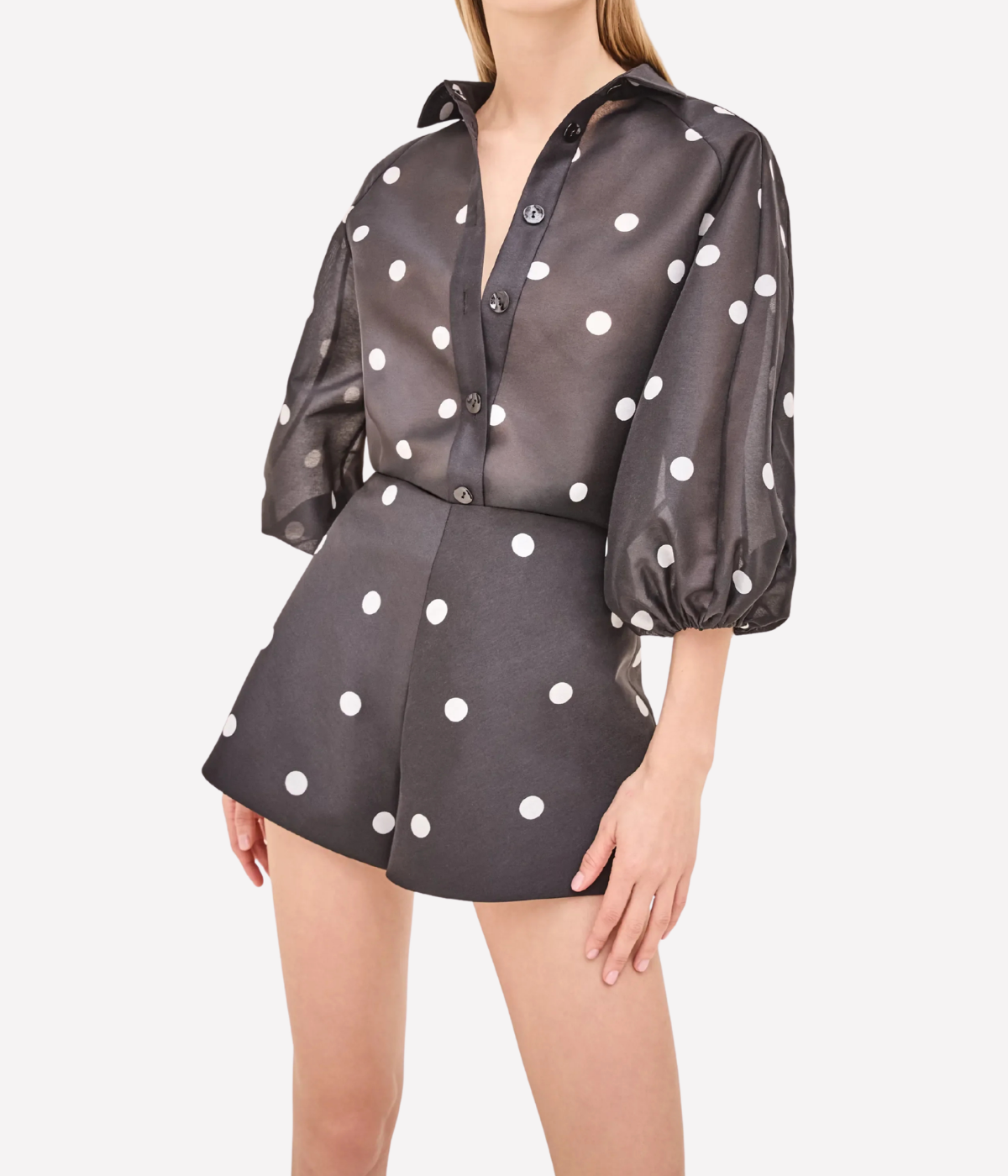 Woman wearing a polka dot dress with a plain background
