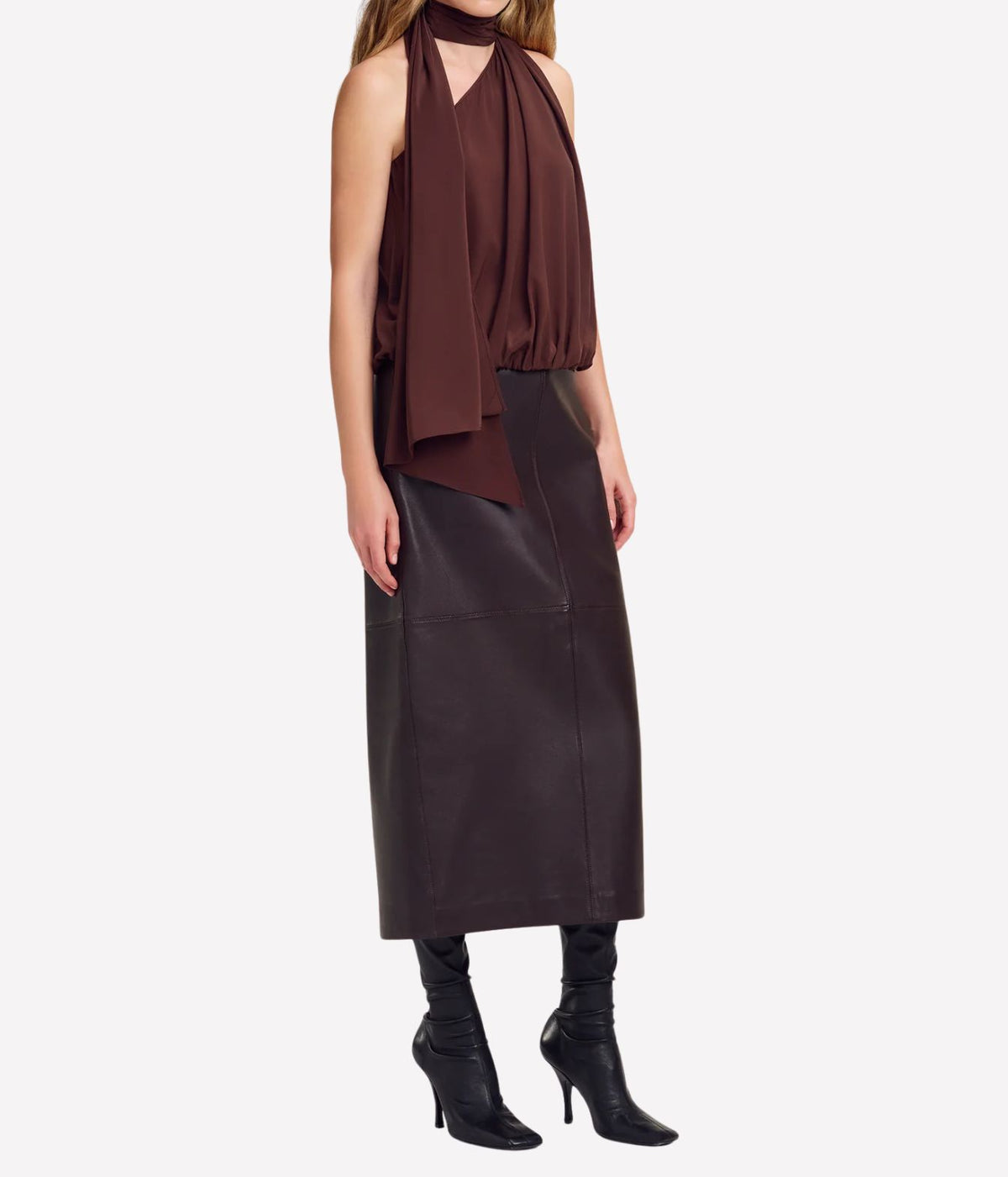 Full-length front view of a model wearing the A.L.C. Celeste Top in Coffee with a dark brown leather midi skirt and black pointed knee-high heeled boots