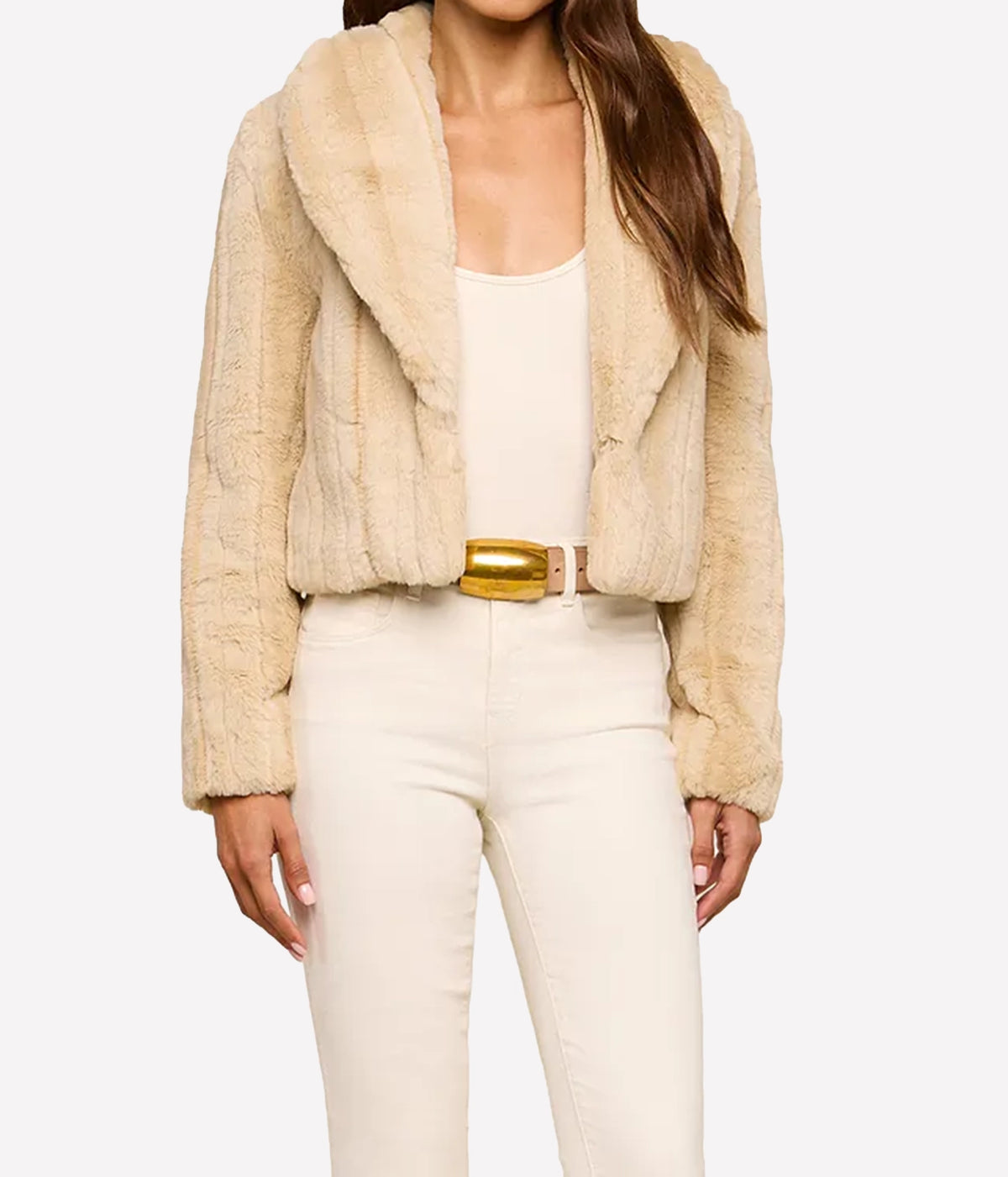 A woman wearing the L'AGENCE Davy Faux Fur Jacket in Latte Striped Fur, styled with a matching cream tank top, cream pants, and a gold belt.