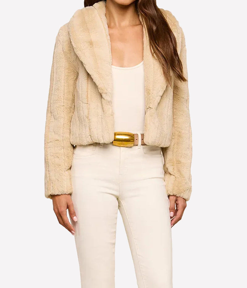 A woman wearing the L'AGENCE Davy Faux Fur Jacket in Latte Striped Fur, styled with a matching cream tank top, cream pants, and a gold belt.