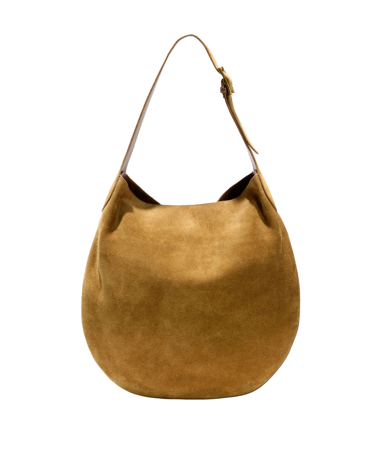 A slouchy suede shoulder bag in a warm camel brown color, featuring a single leather strap with a buckle closure, set against a plain white background.