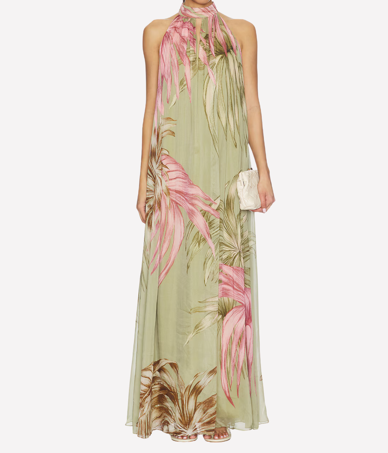 Woman wearing a floral dress with pink and green colors on a white background