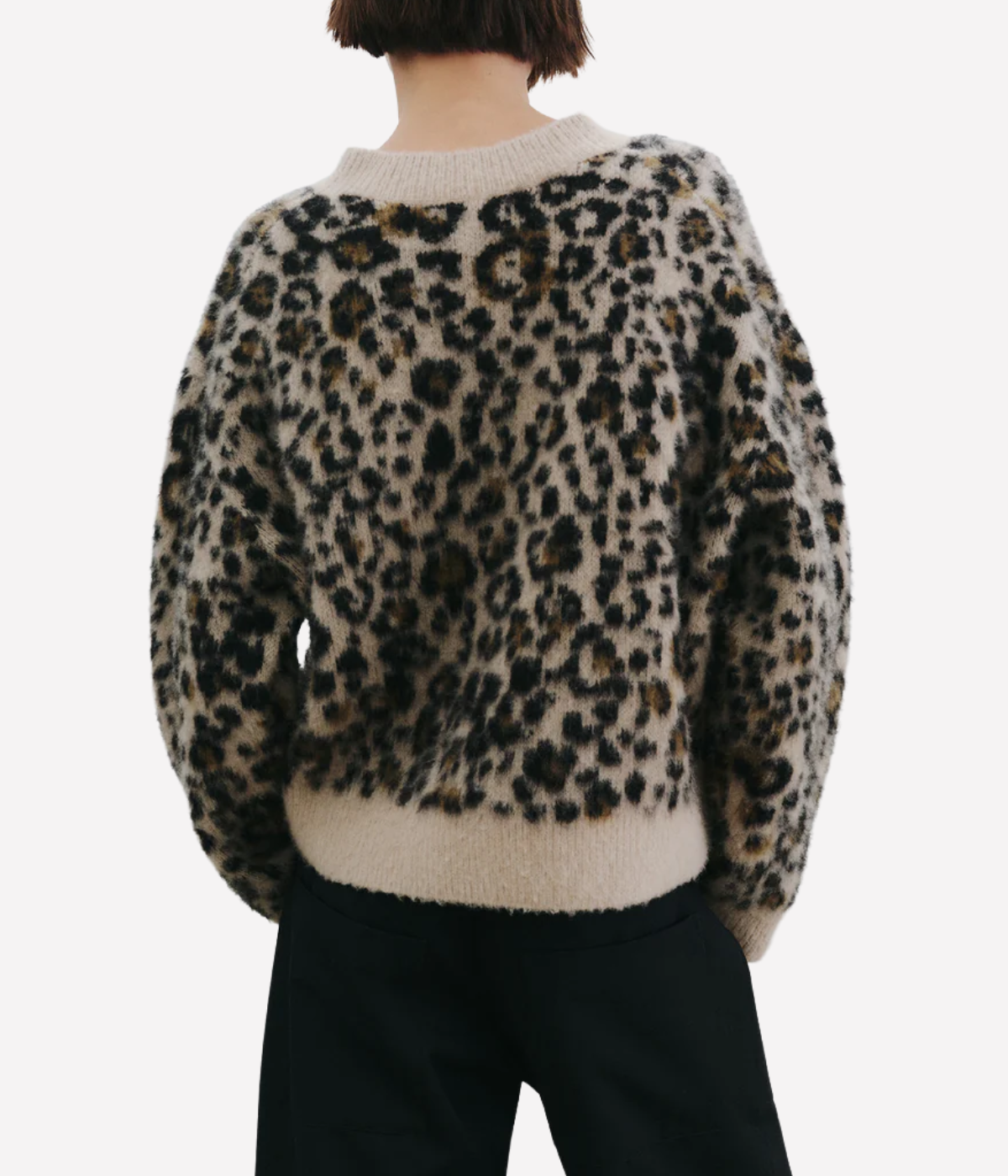Leopard print sweater worn by a person on a white background