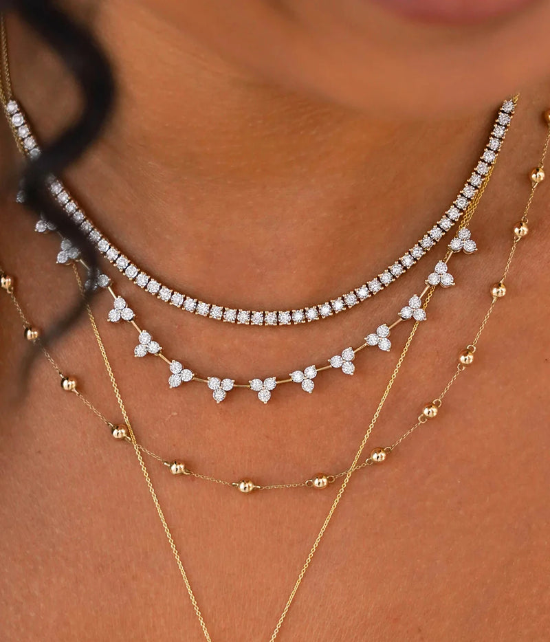 Model wearing the Dana Rebecca Designs Ava Bea Interval Trio Tennis Necklace in 14k Yellow Gold stacked between a diamond tennis necklace and a fine gold chain