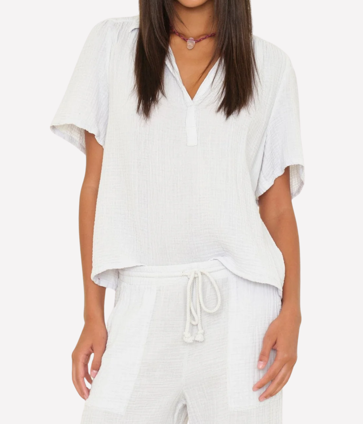 Model wearing the Xirena Rylee Top in Pale Sky with matching gauze drawstring pants and a beaded pendant choker, showing the spread collar and relaxed popover fit