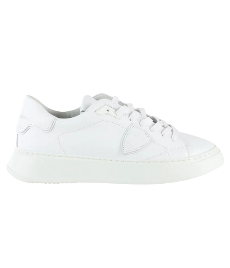 A white leather low-top sneaker with matching white laces and a thick white platform sole