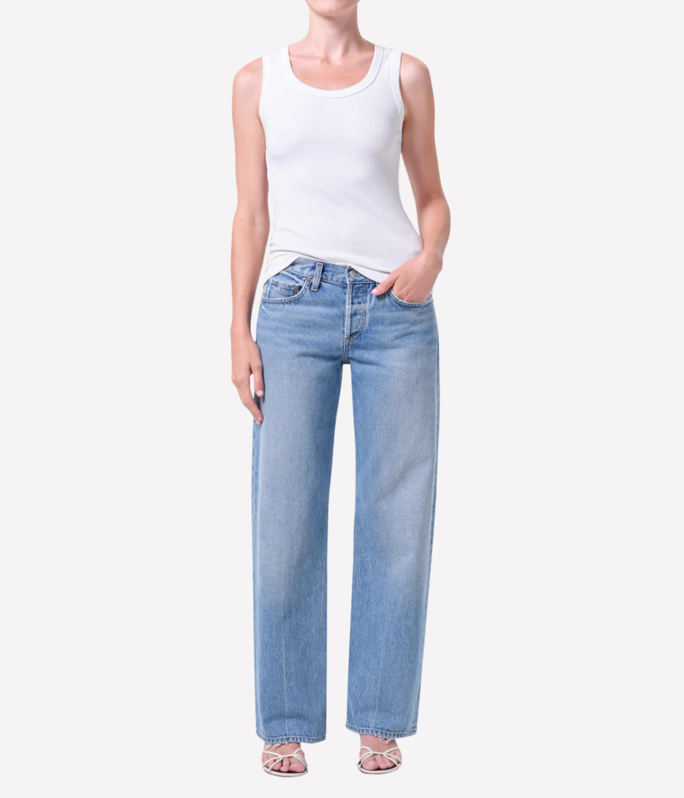 A model wearing light-wash blue straight-leg jeans standing against a plain light gray studio background.