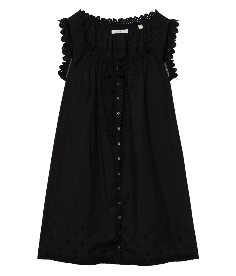 DÔEN Nessie Dress in Black laid flat, showing the ruffled armhole trims, eyelet lace neckline, front tie, button-through front and embroidered eyelet hem