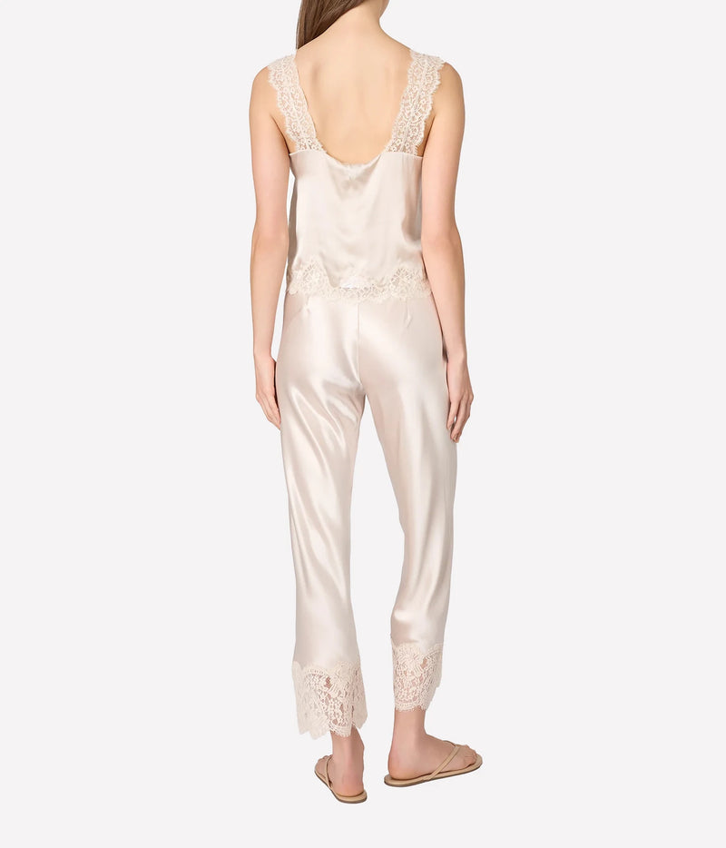 A woman shown from the back wearing a satin set with lace trim on the straps and hems