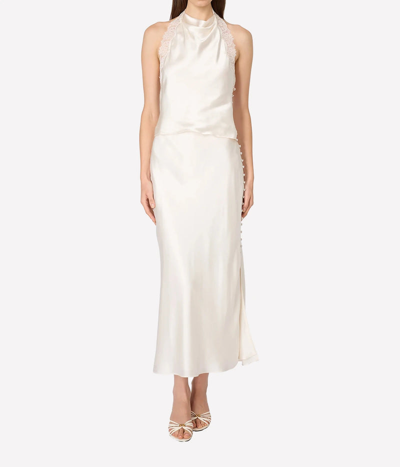A model wearing a sleeveless high-neck satin dress in off-white