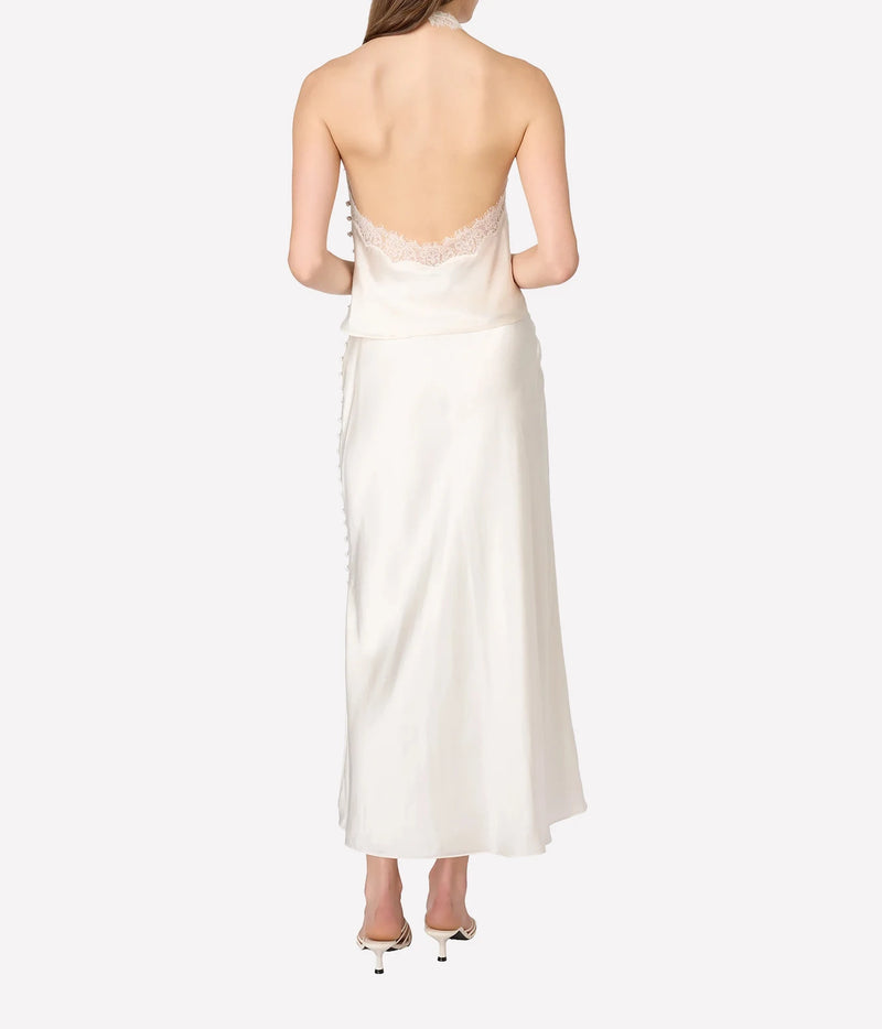 A woman shown from the back wearing a strapless ivory satin top with a lace-trimmed open back and side buttons