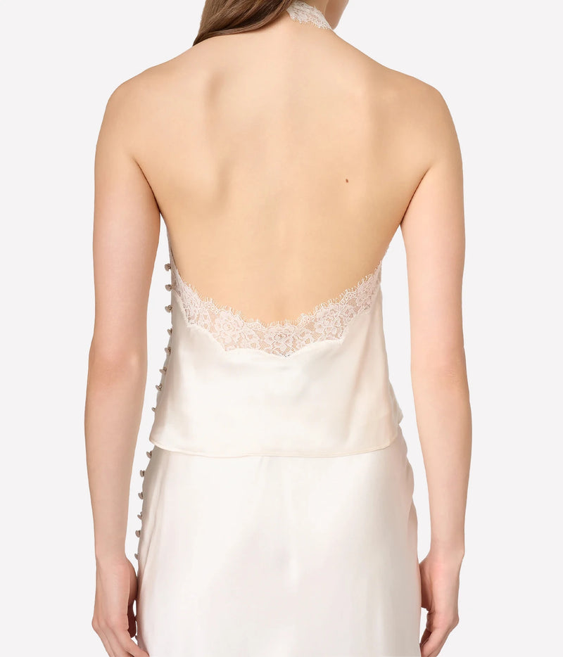 Back view of a model wearing a satin slip dress with a lace-trimmed open back and side buttons