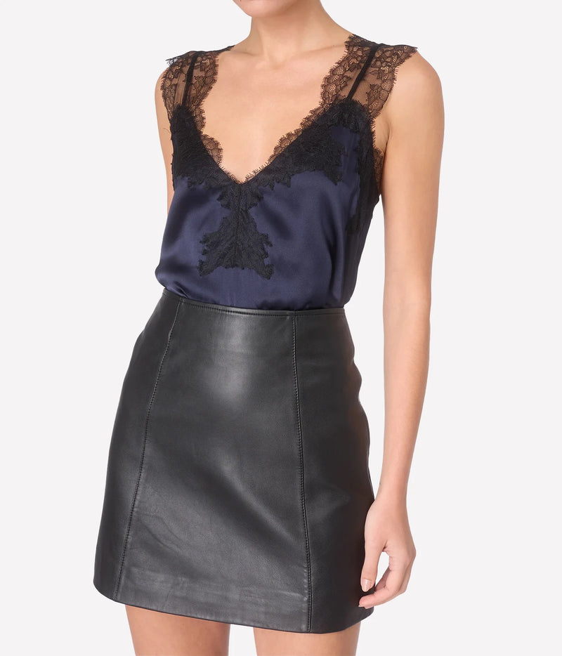 Model wearing CAMI NYC Lauren Silk Camisole in Navy with black lace trim and a black leather skirt