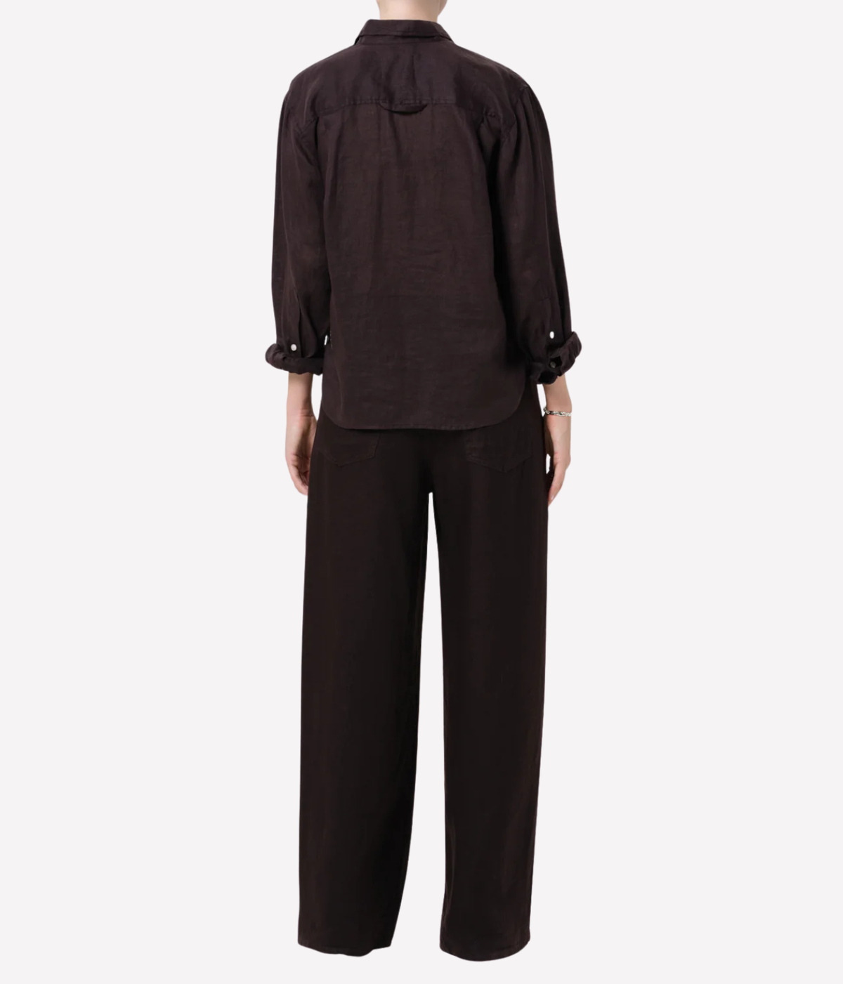 A dark brown linen two-piece set consisting of a long-sleeve button-down shirt and matching wide-leg trousers, shown from the back on a model against a light gray background.