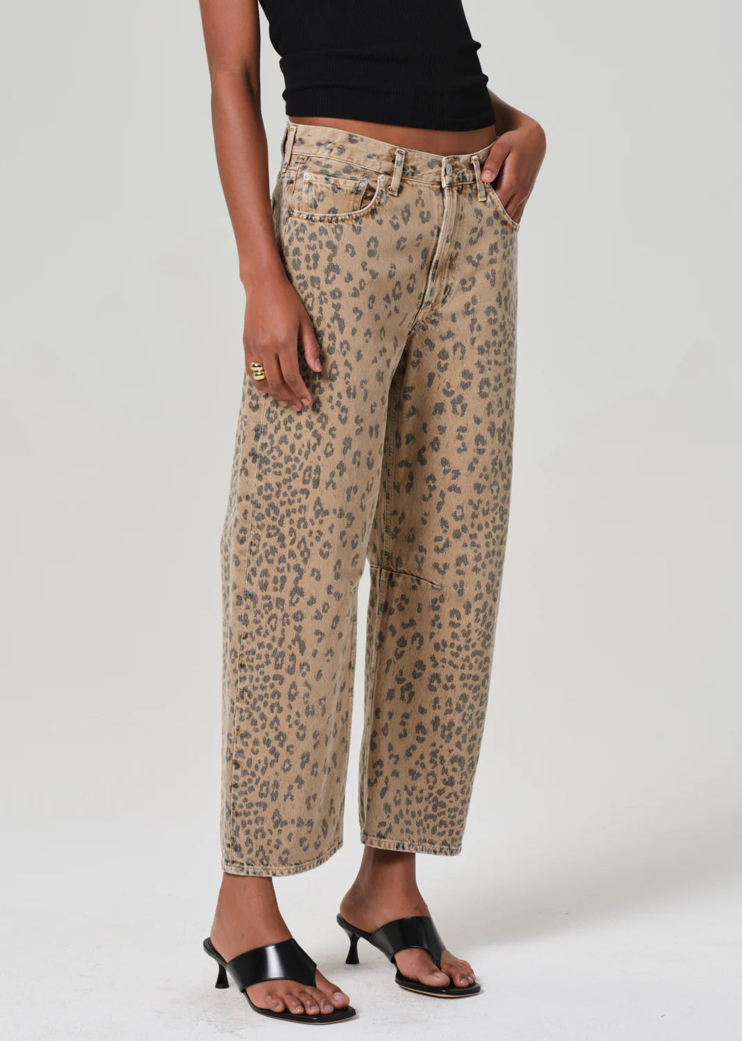 ALT text: Light beige denim jeans with cheetah print, styled with a simple tee.