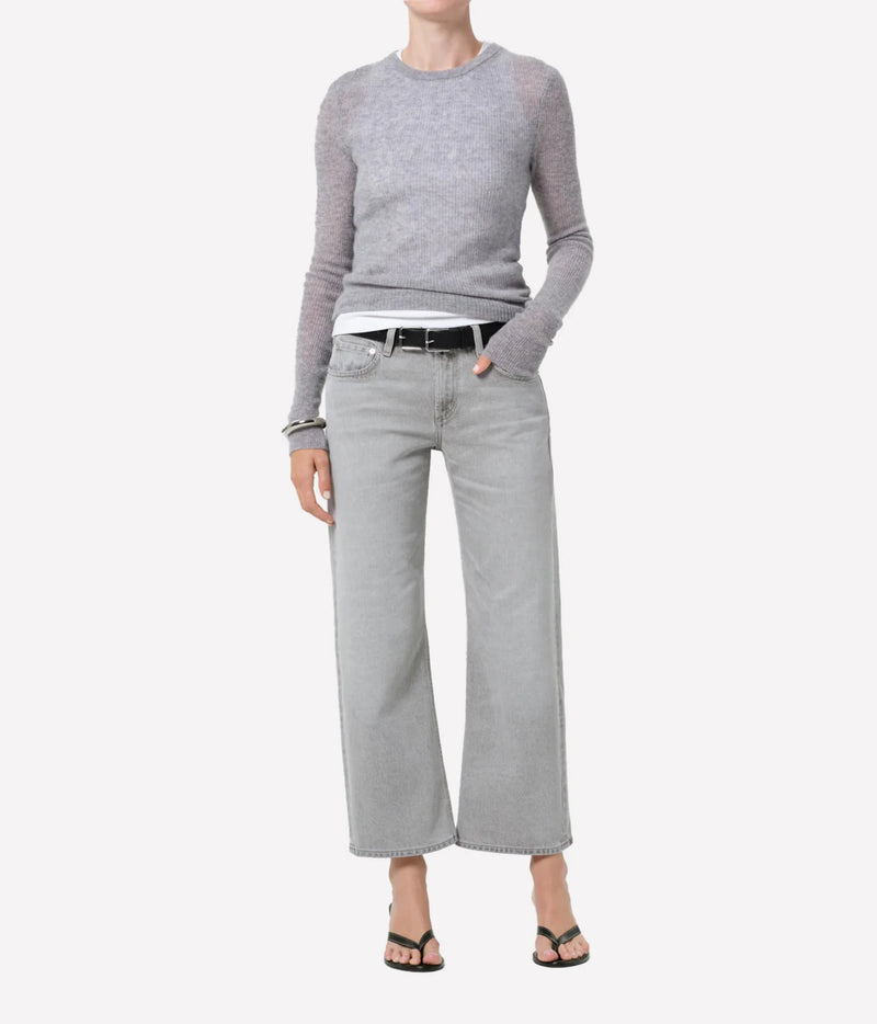 A model wearing a light gray long-sleeve knit sweater, wide-leg light gray jeans, a black belt, and black sandals, shown against a plain light gray background.