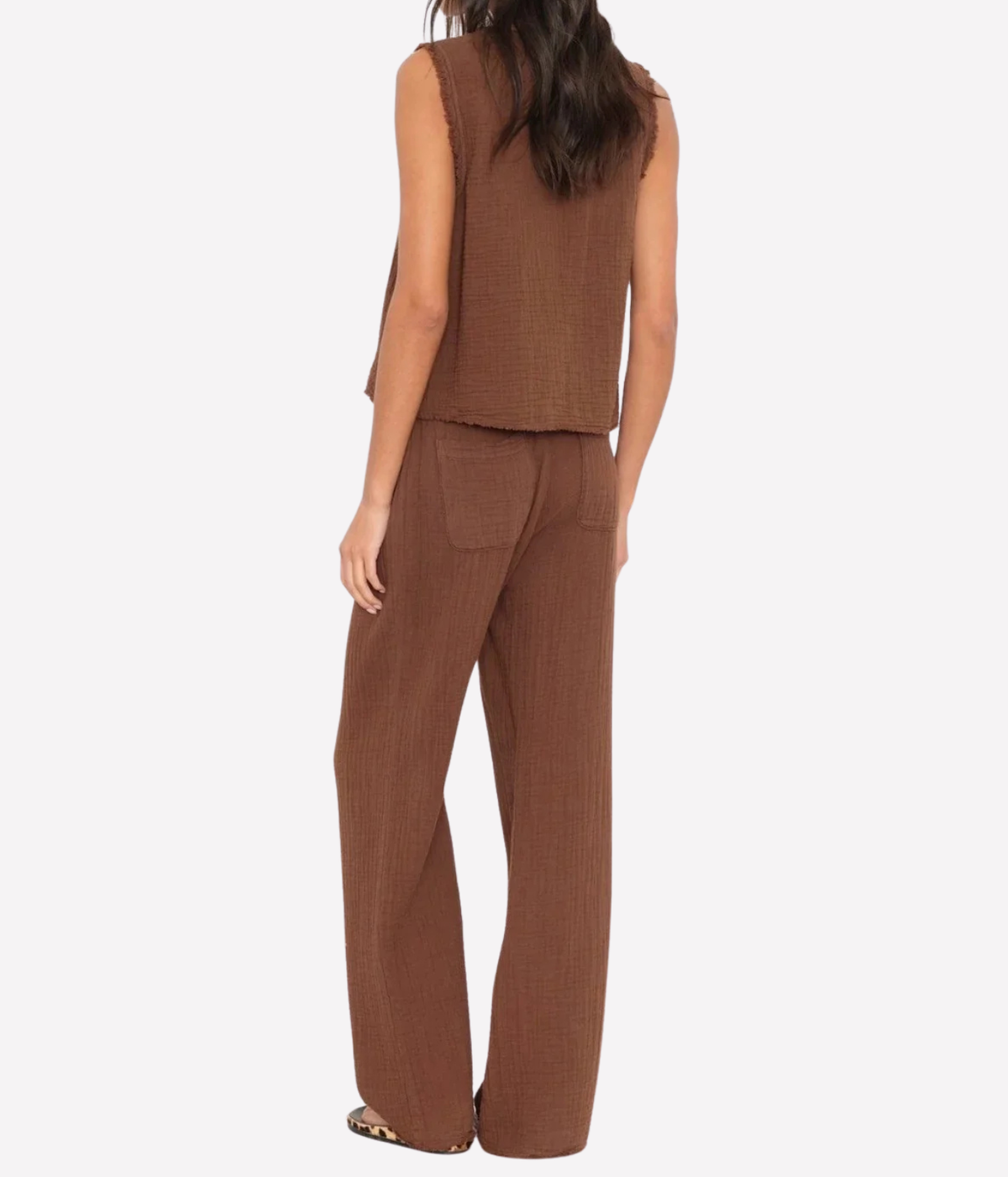 A woman shown from the back wearing a matching brown sleeveless top and wide-leg pants set, photographed against a plain light gray studio background.