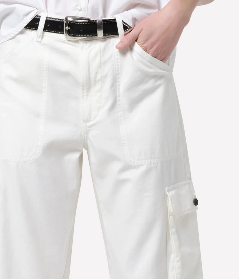 White cargo pants with a black belt, shown on a model with a hand in the pocket, against a light gray background.