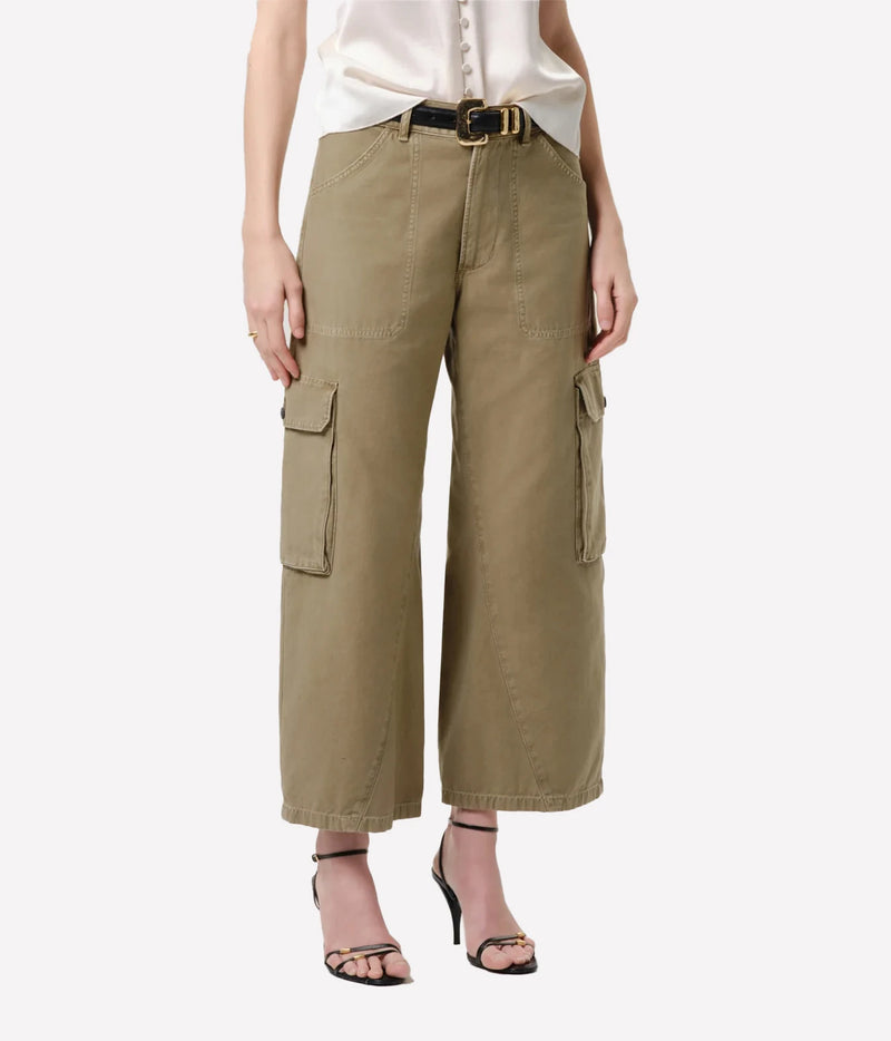 A model wearing a pair of wide-leg cropped cargo pants in olive green, styled with a white top, black belt, and black strappy heels against a light gray background.