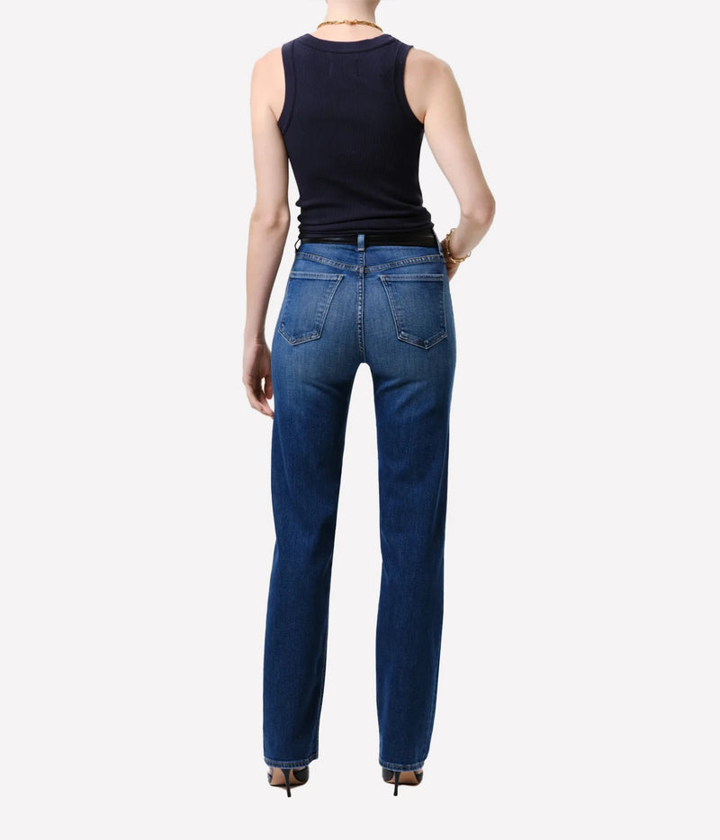 Rear view of a model wearing dark blue straight-leg jeans and a black sleeveless top against a light gray background.