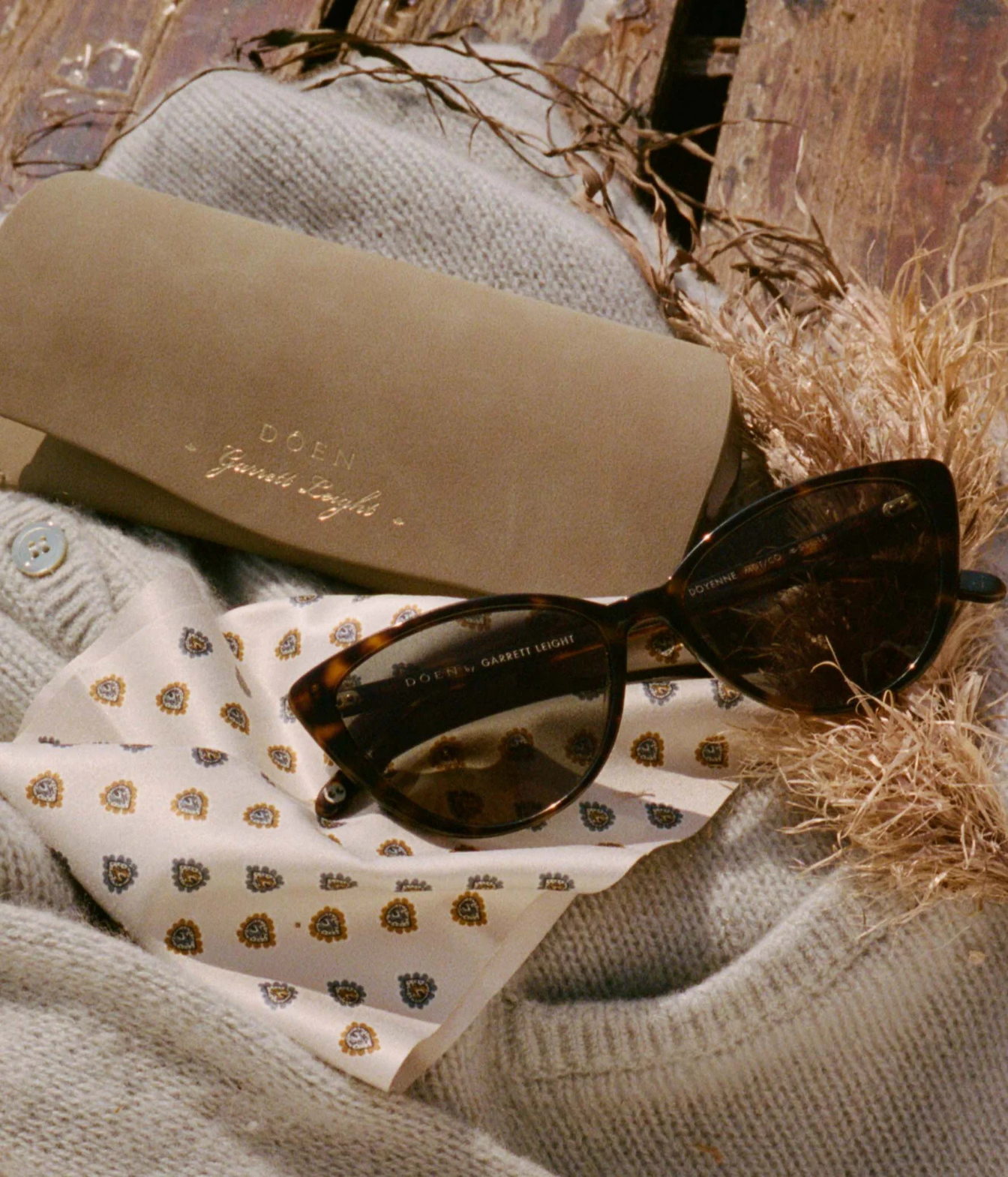A pair of dark brown cat-eye sunglasses with tortoiseshell frames and dark lenses