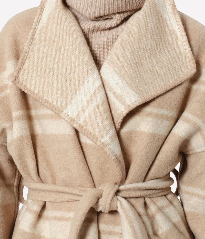 Isabel Marant Brea Belted Checked Coat - Close-up of a beige and cream plaid wool wrap coat with a matching tie belt, layered over a ribbed knit turtleneck sweater.
