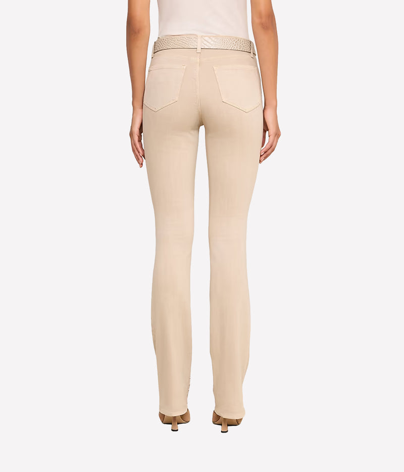 Rear view of a model wearing the L'AGENCE Selma Bootcut Jean in Biscuit with a matching woven belt, paired with a white top and brown heels.