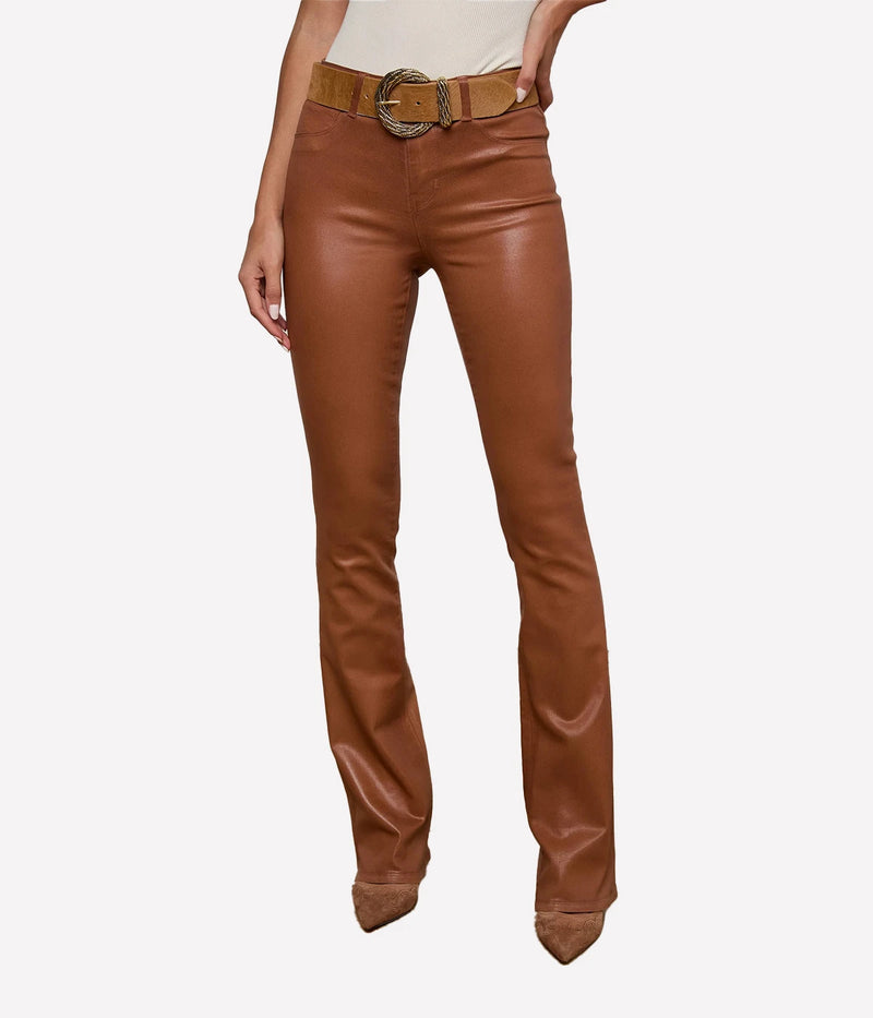 A front view of a model wearing the L'AGENCE Selma Coated Bootcut Jean in Cognac and a white top with a tan belt and tan heels